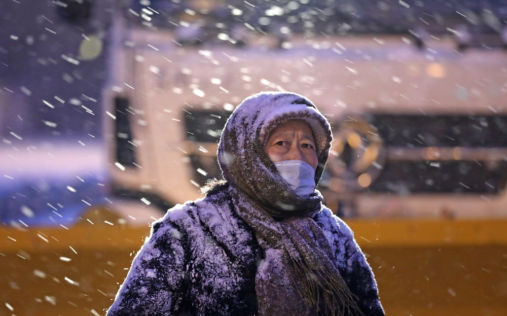 1月15日早晨，一名行人在沈陽市泰山路上等待交通信號燈。
