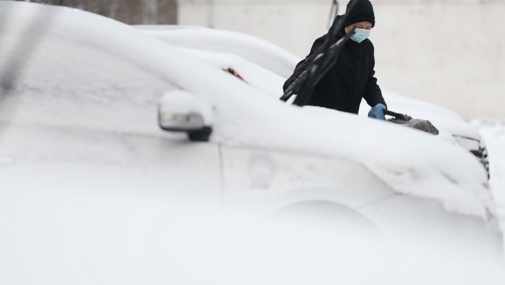 1月15日早晨，一名私家車主在清掃車上的積雪。