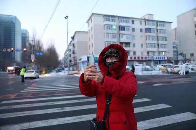 　1月17日早晨，一位市民在昆山西路塔灣街用手機拍照留念。新華社記者 姚劍鋒 攝