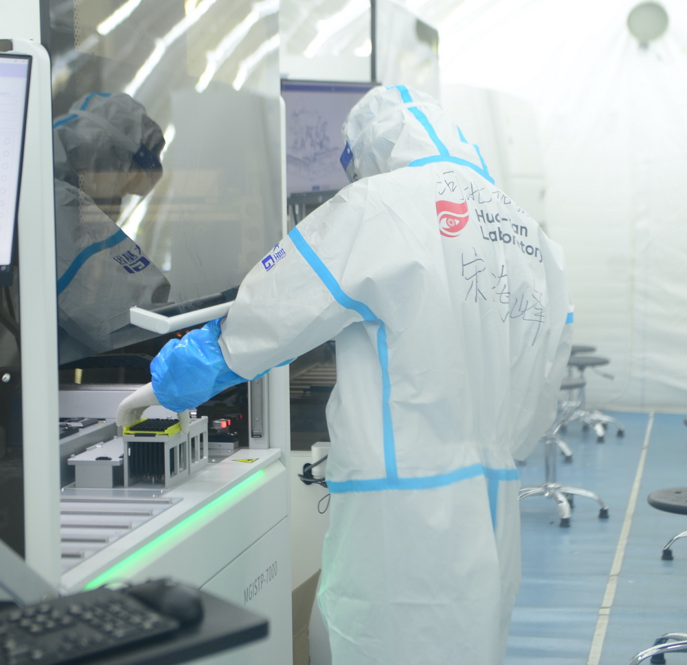 1月18日，檢測員宋海峰在“掃碼取樣”艙操作全自動分杯處理系統進行掃碼取樣工作。