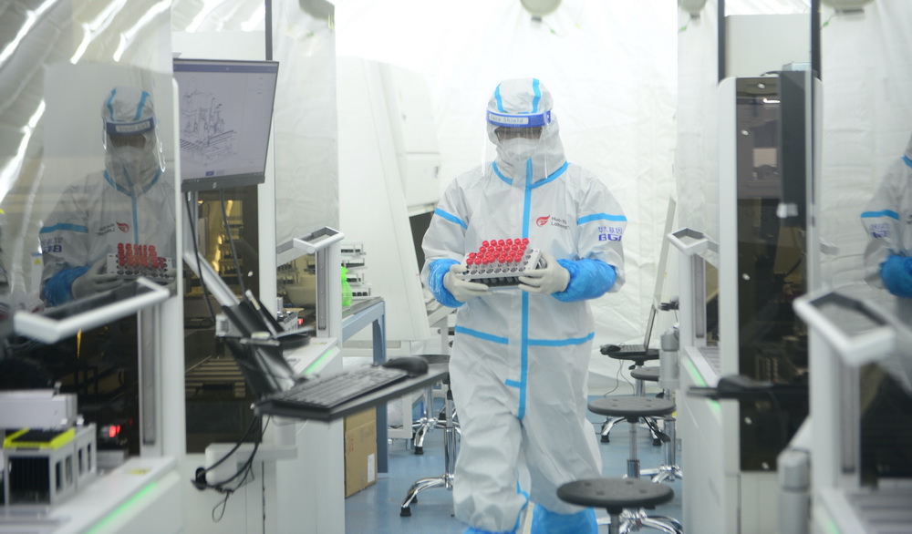 1月18日，檢測員宋海峰在“掃碼取樣”艙准備進行核酸樣本的掃碼取樣工作。