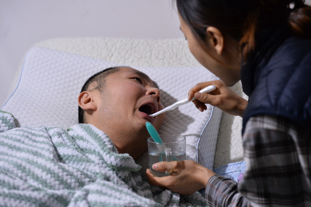 1月15日，劉寧為男友彭亞樓刷牙。新華社記者 韓旭 攝