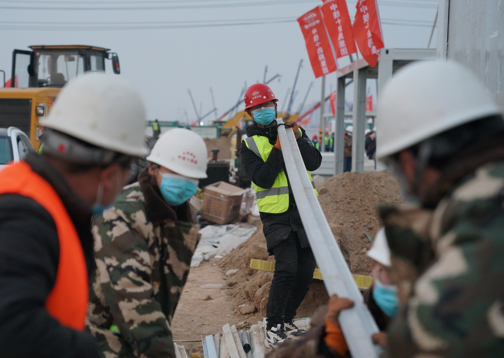 1月19日，曹澤盼（中）在石家庄市黃庄公寓隔離場所項目建設現場搬運建材。
