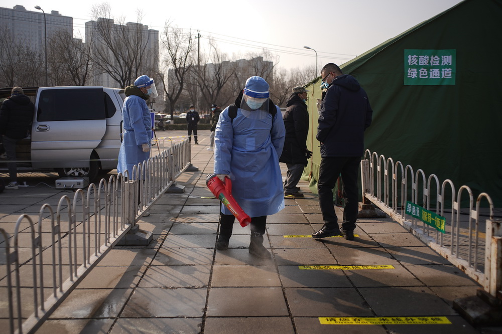 1月20日，在北京市大興區亦庄鎮一處核酸檢測點，工作人員對公共區域進行消毒。新華社記者 彭子洋 攝
