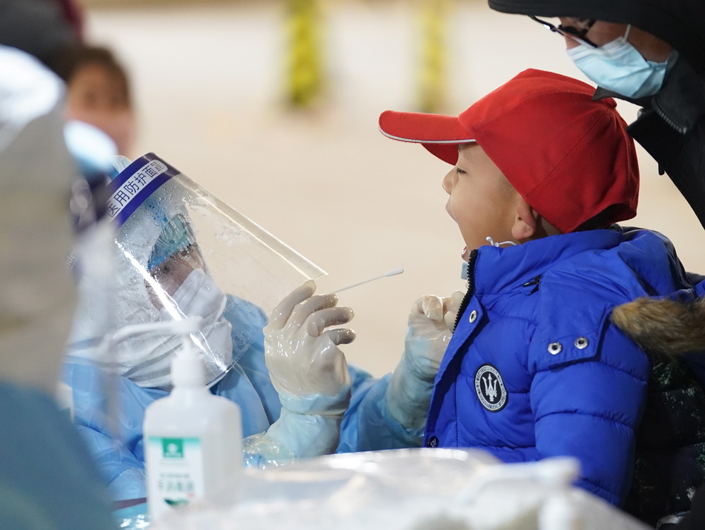 1月20日，在北京市大興區龐各庄鎮一處核酸檢測點，醫護人員為一名小朋友進行核酸採樣。新華社記者 鞠煥宗 攝