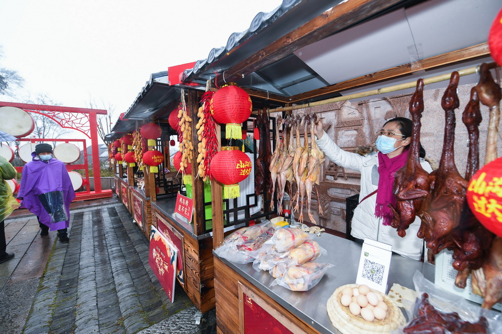 1月22日，攤主在茅塘古村裡的新春年味集市上擺放售賣醬鴨、臘肉等傳統美食。