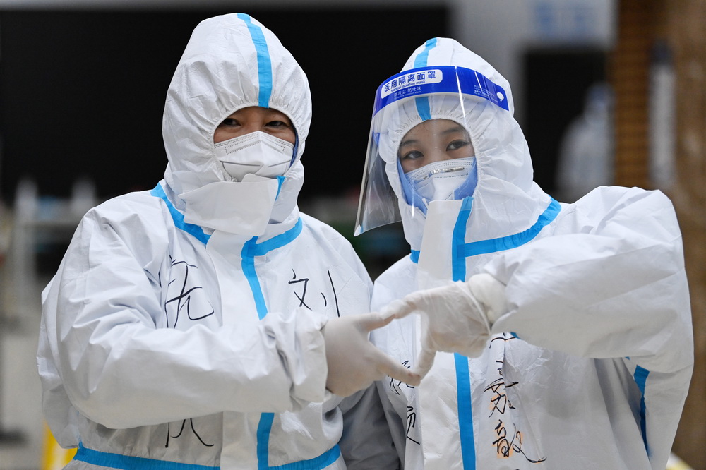 1月23日，两名医护人员在哈尔滨市抚顺社区核酸检测点“比心”合影。新华社记者 王建威 摄