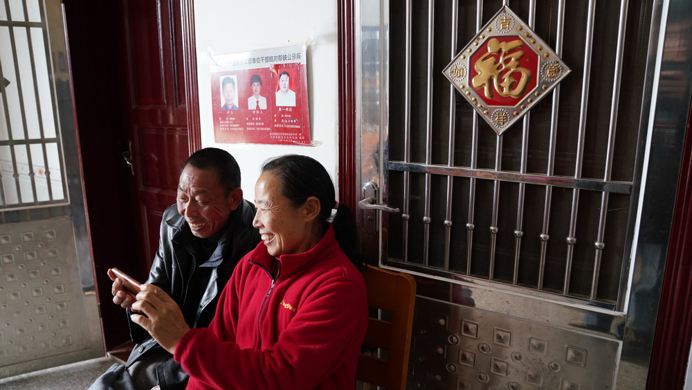 刘仁香和丈夫赖际林在家中用手机欣赏短视频（1月22日摄）。