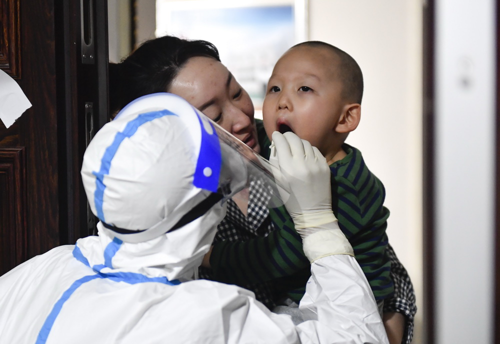 1月25日，在吉林省通化市東昌區一小區，醫務人員入戶為居民進行核酸採樣。