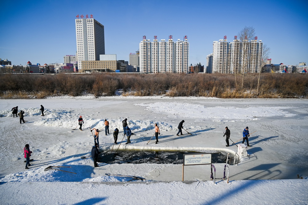 這是1月22日，冬泳愛好者在伊敏河上鑿冰。新華社記者 連振 攝