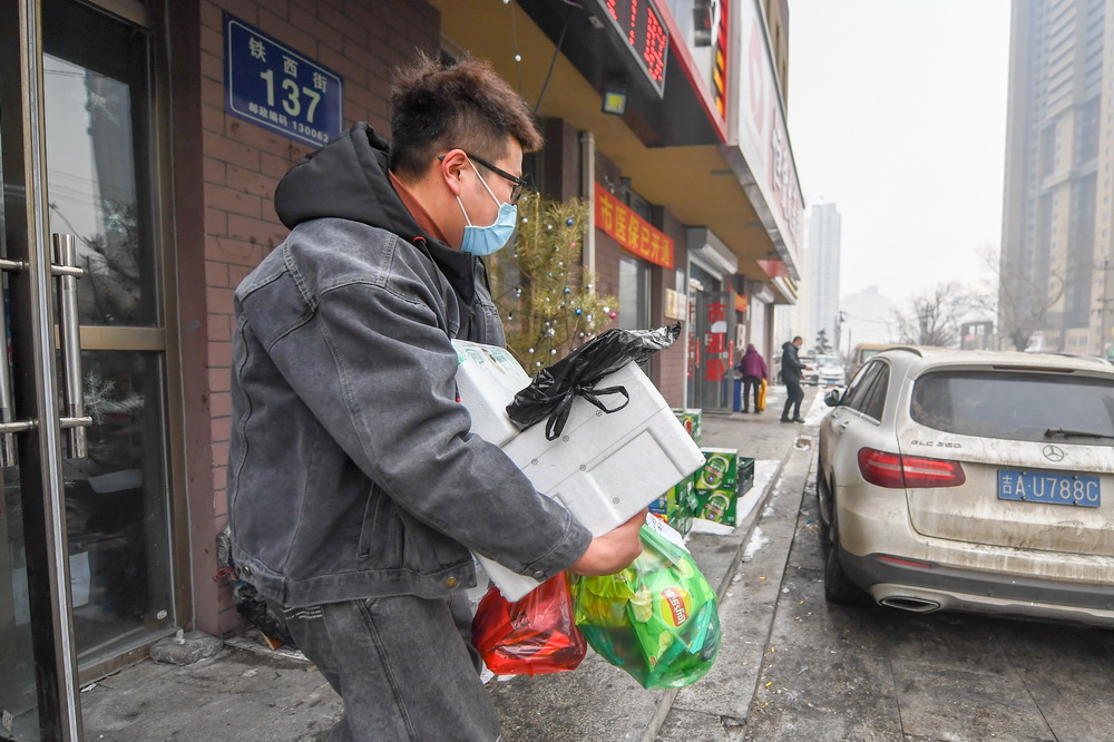 1月26日早晨，王撼東搬運幫居民採購的物品。新華社記者 張楠 攝
