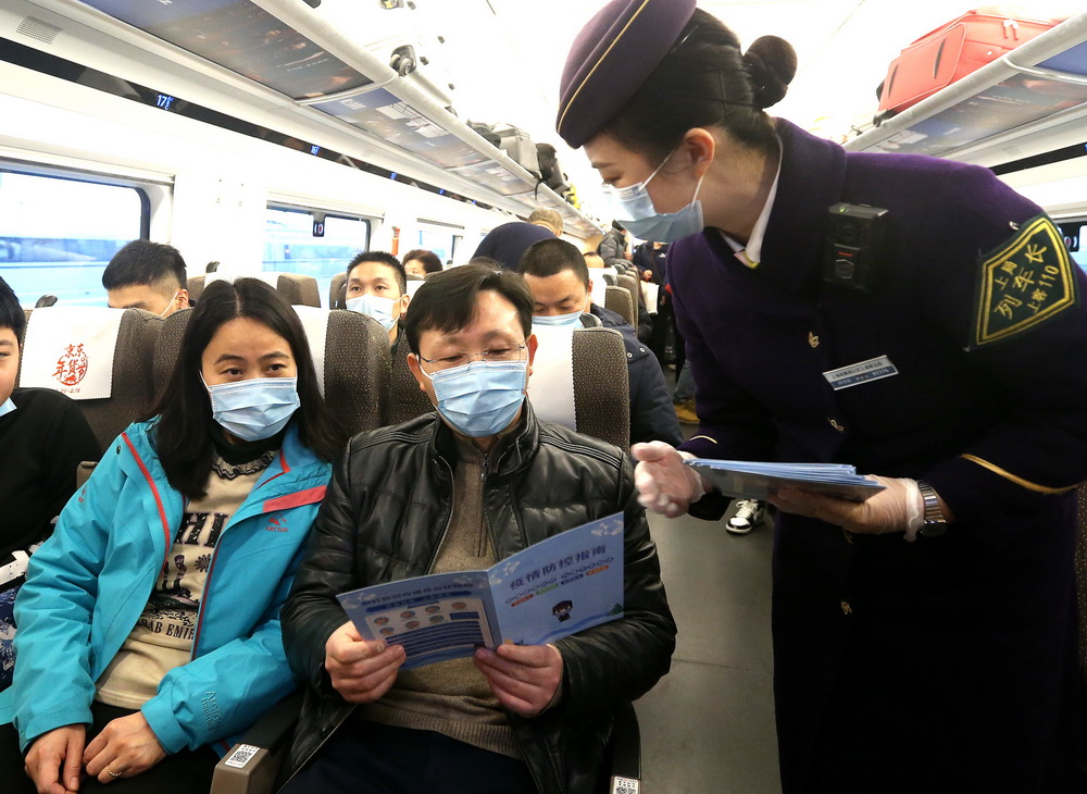 1月26日，列車長周怡彤在上海虹橋開往北京南的G124次列車上發放《疫情防控指南》小冊子。