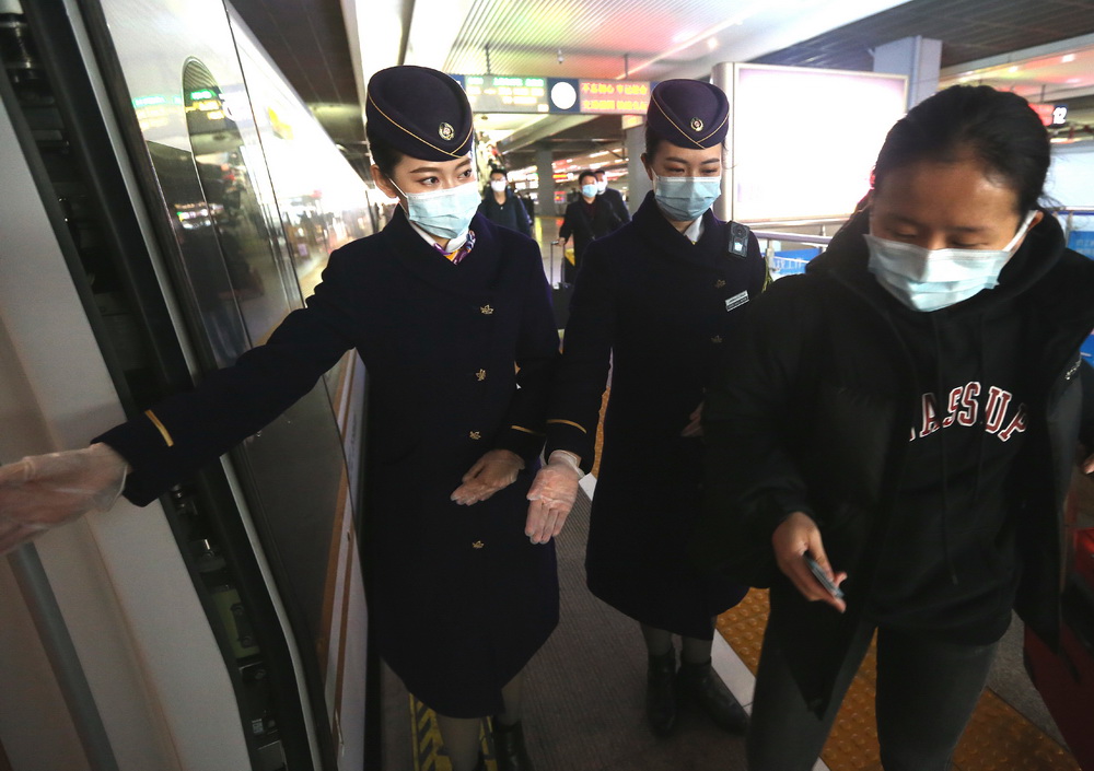 1月26日，G124次列車乘務員在上海虹橋火車站迎接旅客上車。