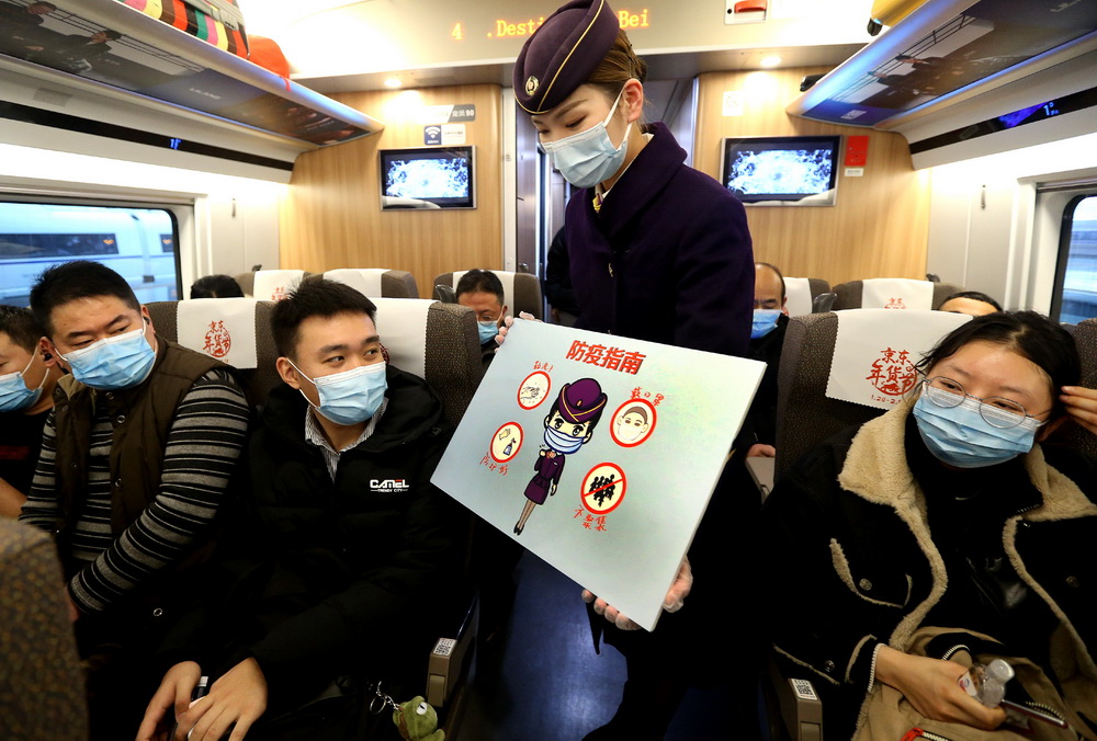 1月26日，乘務員在上海虹橋開往北京南的G124次列車上展示防疫指南。