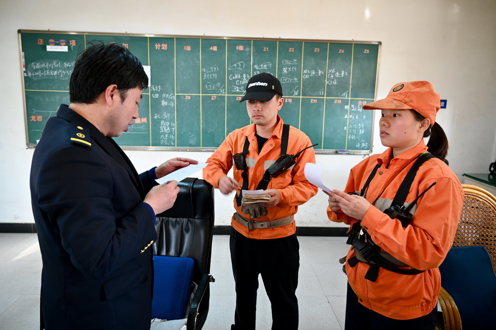 1月25日，在福建上杭火車站，調車員丘麗榕（右）在行車室與車站值班員核對作業計劃。
