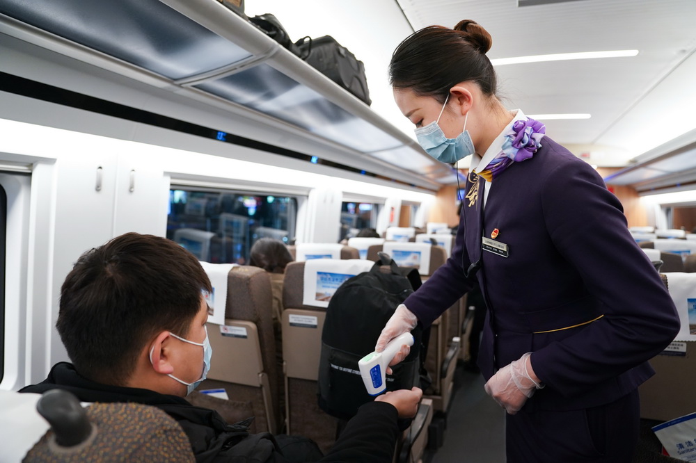1月28日，G598次列車的列車員在為高力測量體溫。新華社記者 丁汀 攝