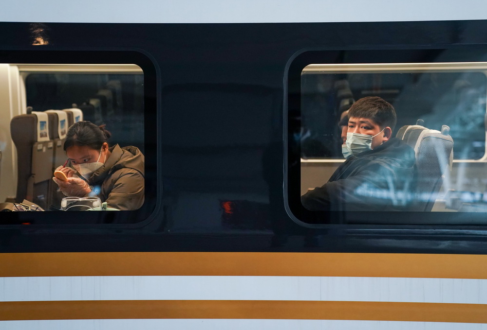 1月28日，在上海虹橋站，高力（右）在車廂內等候發車。新華社記者 丁汀 攝