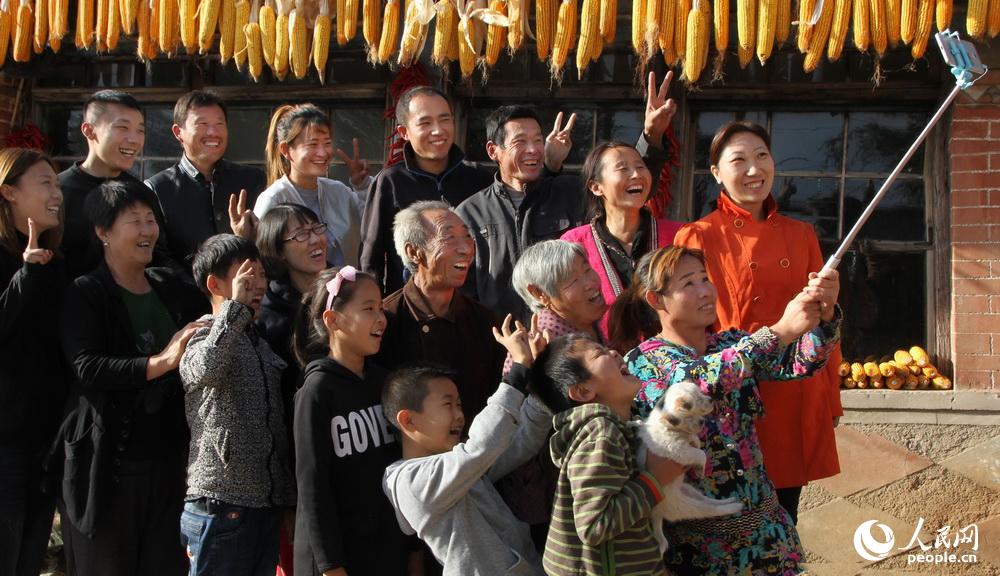 一家人望向鏡頭，用手機拍下合家歡樂的幸福瞬間。劉世興2017年10月2日拍攝於遼寧的農家庭院。