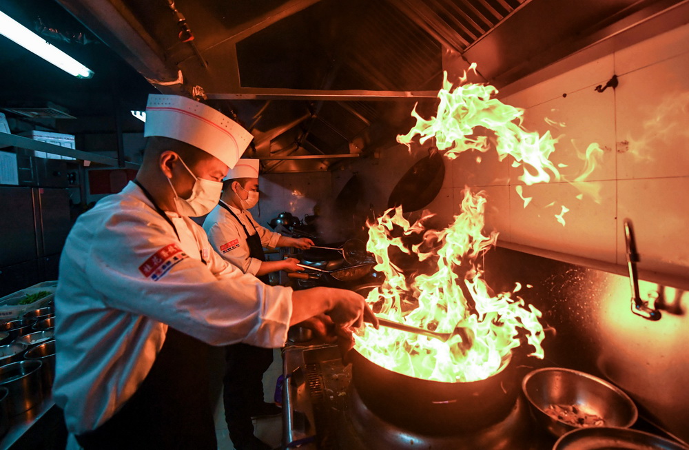 2月1日，在石家庄市桥西区一家餐厅，厨师在后厨佩戴口罩炒菜。新华社记者 王晓 摄