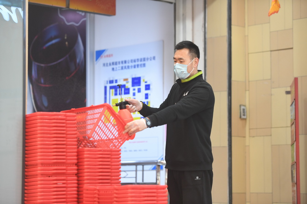 2月1日，石家庄市裕華區一超市工作人員在給購物籃消毒。新華社記者 朱旭東 攝