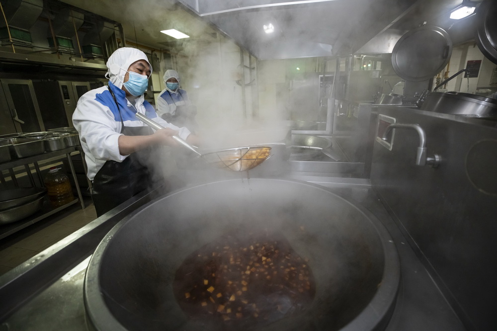 2月2日，在成都印象川之味餐飲有限公司熱調理車間，工人在炒制熱鏈盒飯中的菜品。新華社記者 沈伯韓 攝