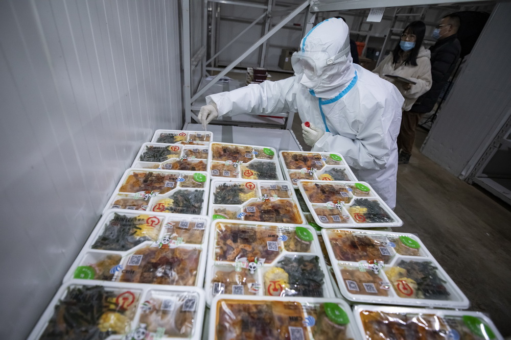 2月2日，在成都印象川之味餐飲有限公司的冷鏈成品庫，工作人員在冷鏈盒飯外包裝上提取核酸檢測環境樣本。新華社記者 沈伯韓 攝