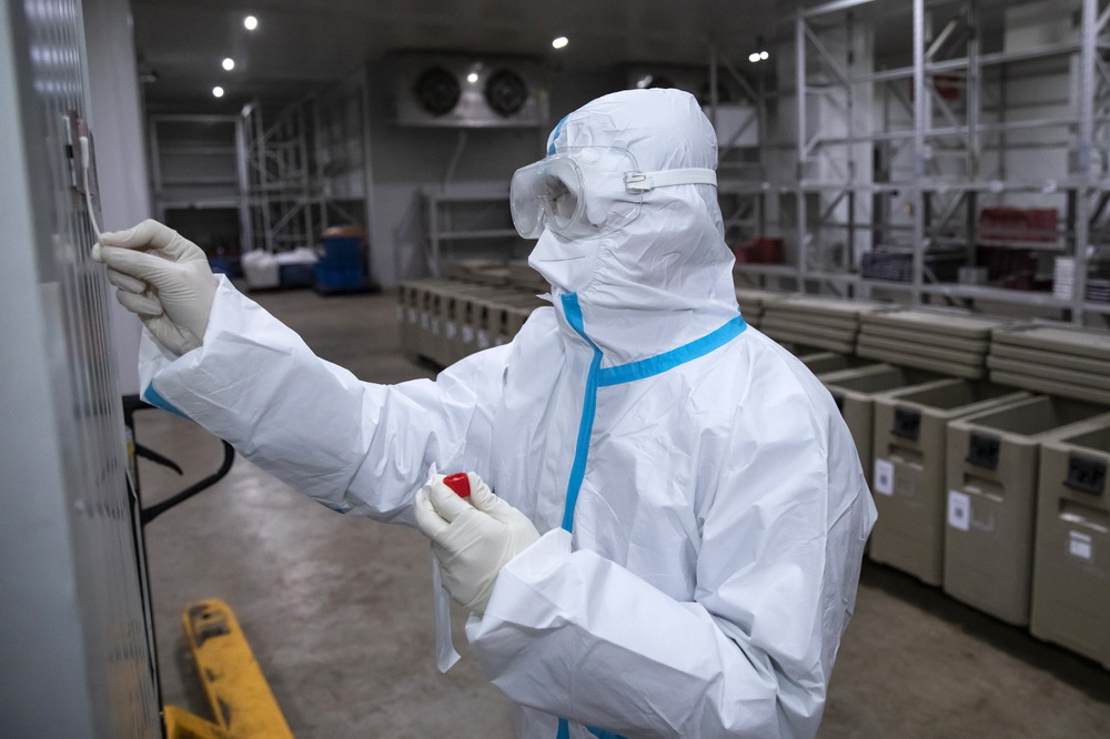 2月2日，在成都印象川之味餐飲有限公司的冷鏈成品庫，工作人員在貨櫃上提取核酸檢測環境樣本。新華社記者 胥冰潔 攝