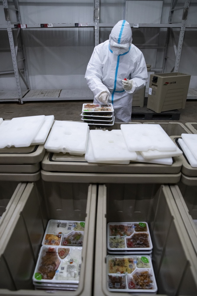 2月2日，在成都印象川之味餐飲有限公司的冷鏈成品庫，工作人員在冷鏈盒飯外包裝上提取核酸檢測環境樣本。新華社記者 沈伯韓 攝