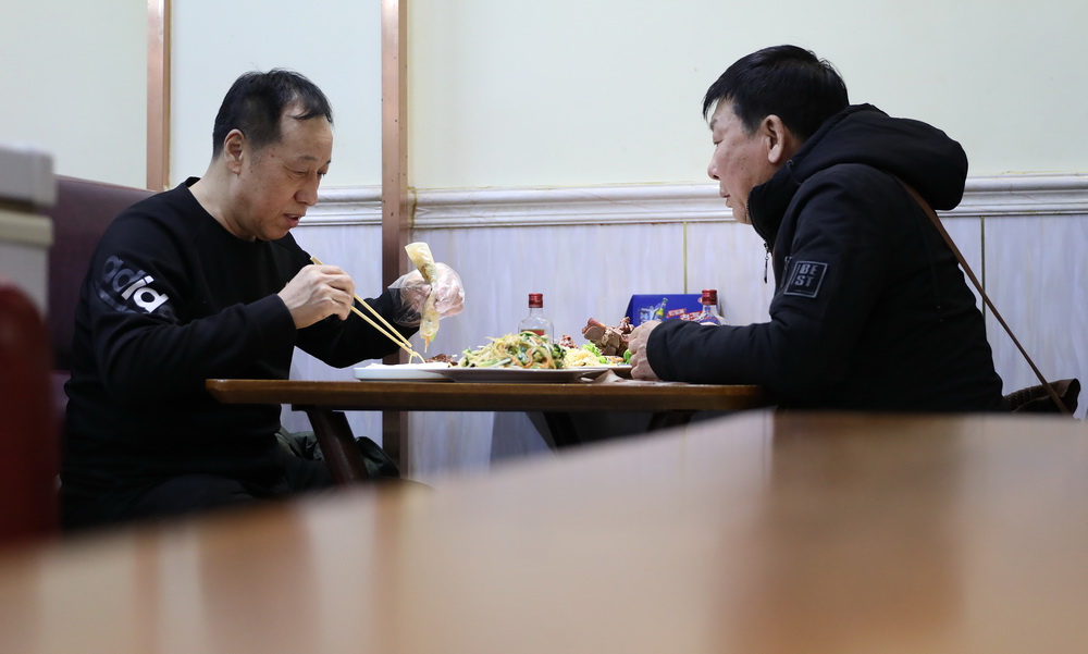 2月2日晚，兩位顧客在劉丹家的春餅店裡吃春餅。