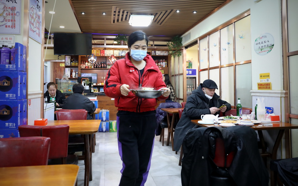 2月2日晚，店主劉丹（中）為客人上菜。