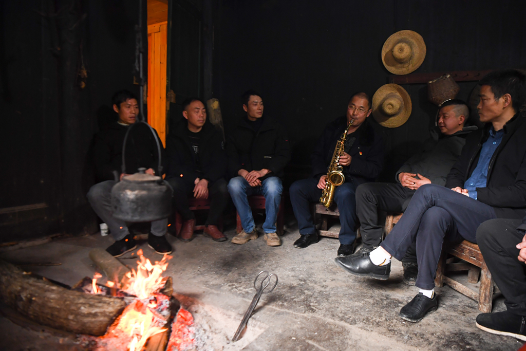 2月5日，張忠富（左四）在金河村脫貧戶鄧先鶴家中吹奏薩克斯。 新華社記者 薛宇舸 攝