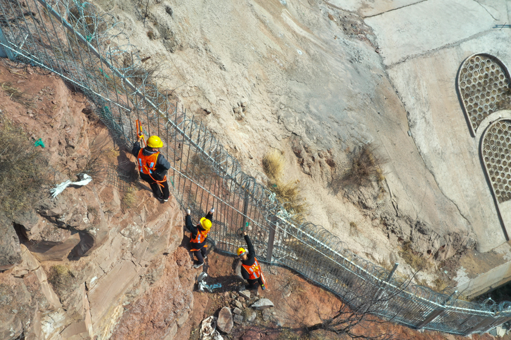 2月9日，在鄭太高鐵太焦段的太谷隧道附近，作業人員在攀爬過程中檢查鋼柵欄（無人機照片）。新華社記者 柴婷 攝