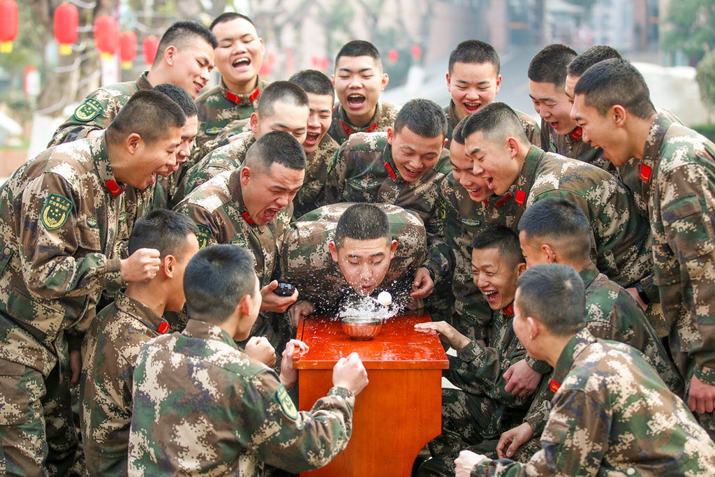 2月12日，武警重慶總隊執勤第三支隊官兵體驗吹乒乓球游戲。 新華社發（彭勇 攝）