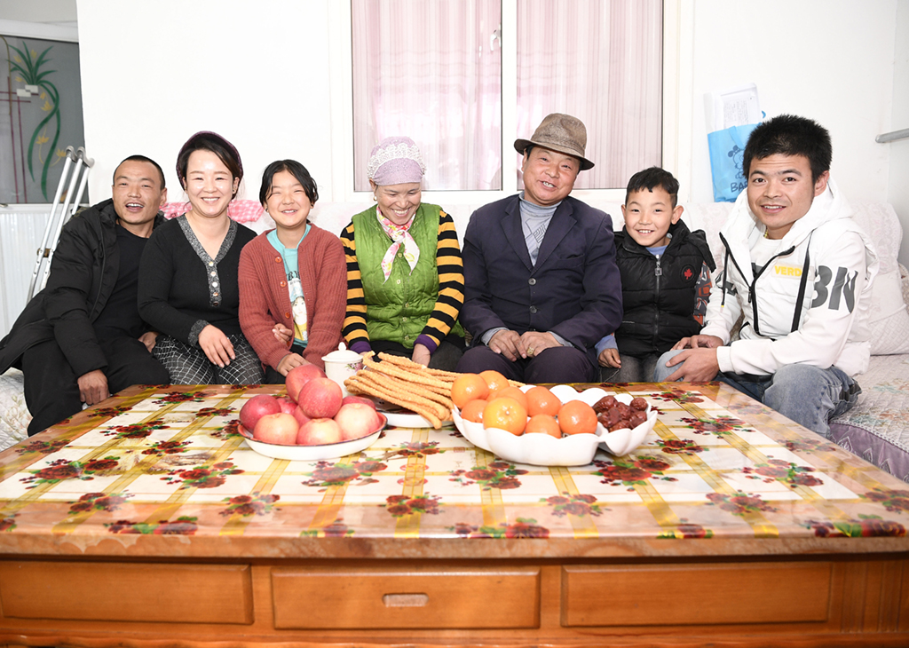 2月11日，張俊明（右三）一家人在濱河家園移民村的家裡合影。新華社記者 王鵬 攝