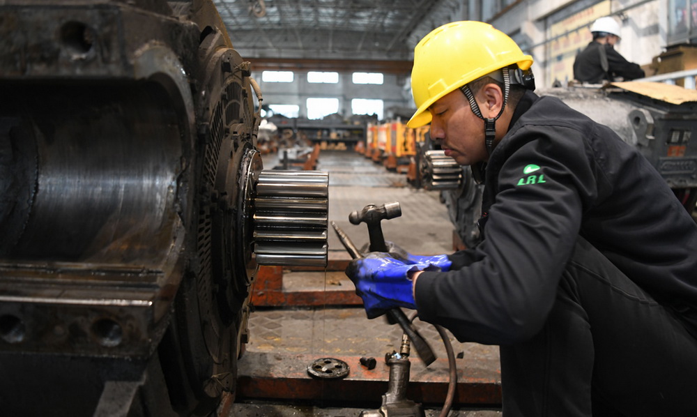 2月16日，在柳州機務段檢修庫，一名“落輪工”在維修電機齒輪。