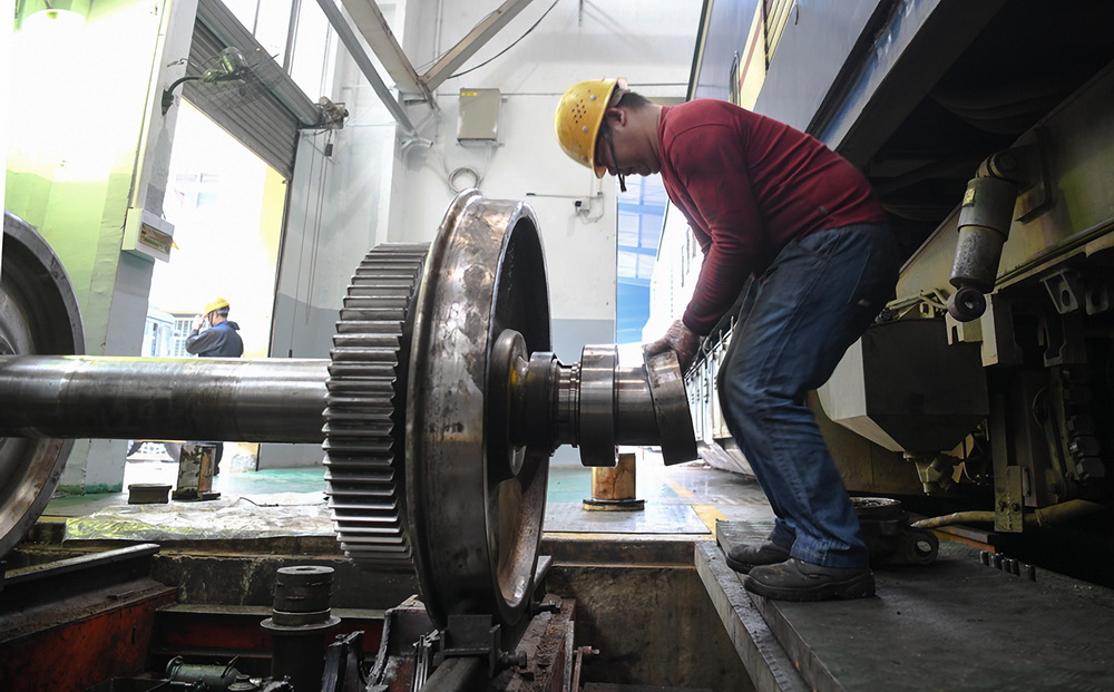 2月16日，在柳州機務段檢修庫，一名“落輪工”在給機車輪對組裝軸箱軸承。
