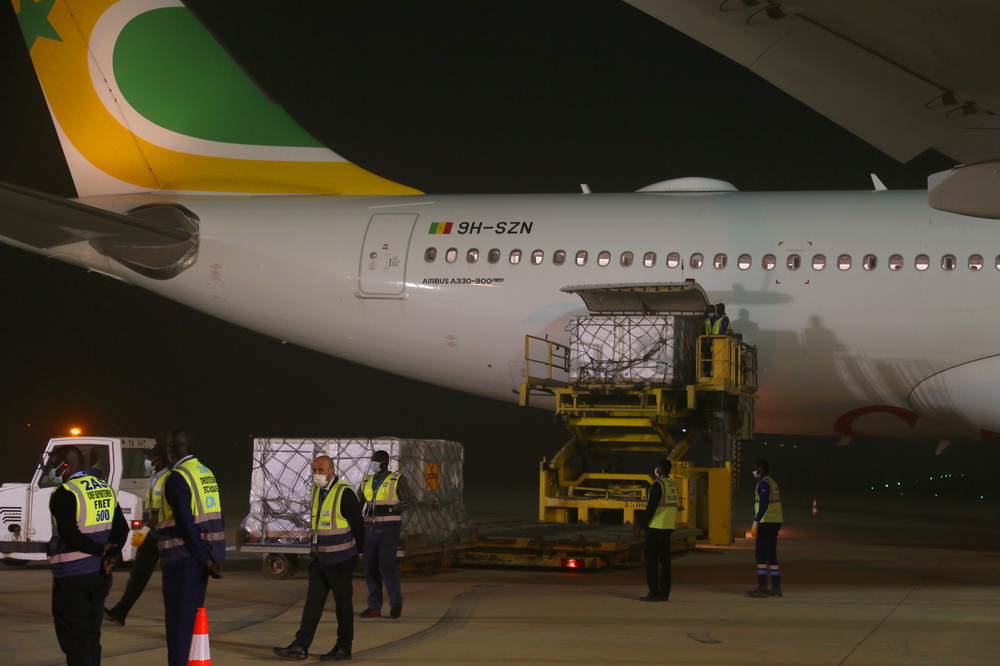2月17日，塞內加爾達喀爾布萊茲·迪亞涅國際機場的工作人員在卸載從中國進口的第一批新冠疫苗。