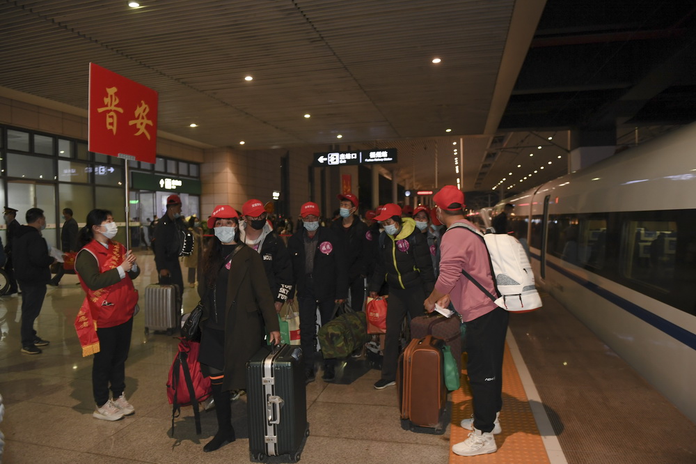 2月21日，志願者迎接乘坐G1901次列車抵達福州的務工人員下車。