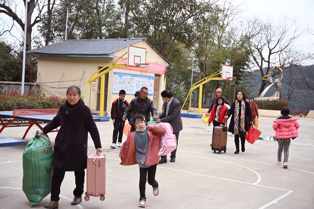 2月28日，在西津畲族小学校园，学生家长带着寄宿的孩子前来报到注册。