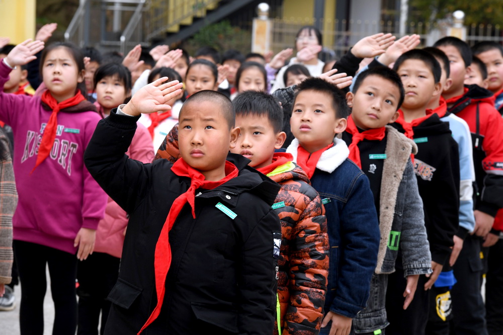 3月1日，西津畲族小学学生在开学仪式上向国旗敬礼。