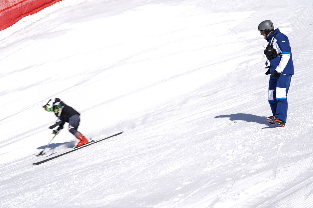 3月2日，在位於北京延慶的國家高山滑雪中心的雪道上，卡佩利·達裡奧（右）在觀察運動員訓練。新華社記者 彭子洋 攝