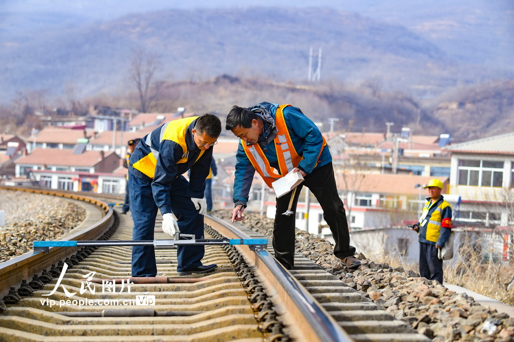 近日，北京鐵路承德工務段工人進行測量軌距作業。