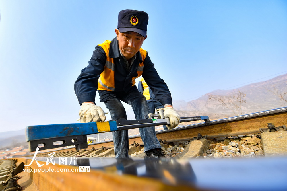 近日，北京鐵路承德工務段工人檢查軌距作業。