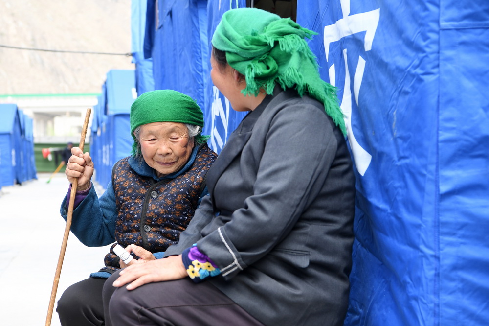 3月16日，在舟曲縣果耶鎮磨裡村、果耶村滑坡災害應急避險臨時安置點，受災群眾在帳篷外聊天。