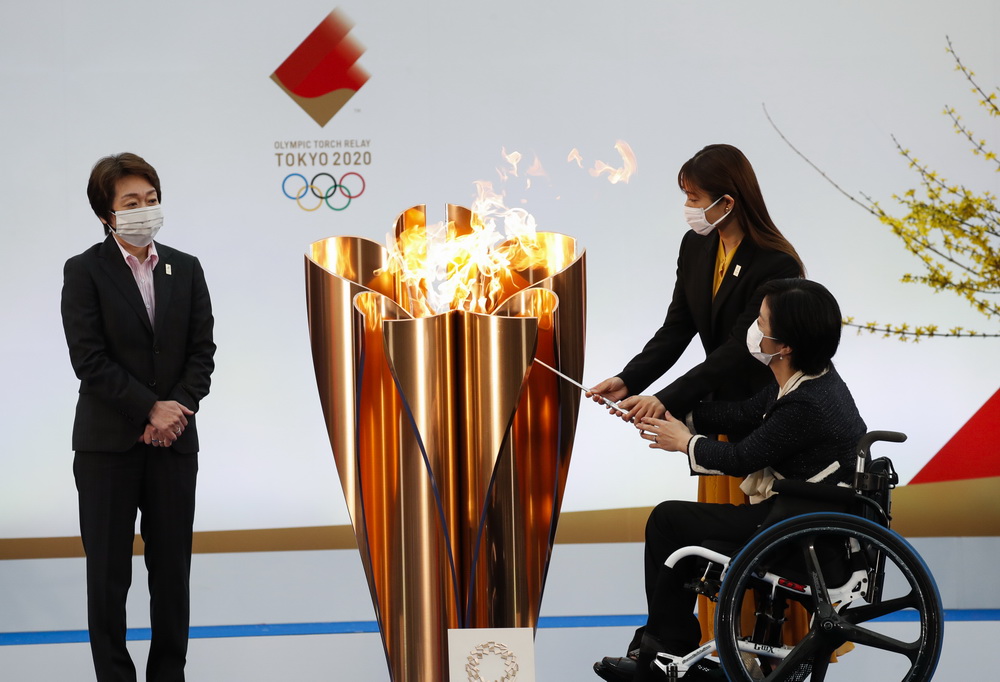 3月25日，東京奧運會火炬傳遞大使石原裡美（中）和田口亞希（右）點燃聖火盆。新華社/POOL/金敬勛