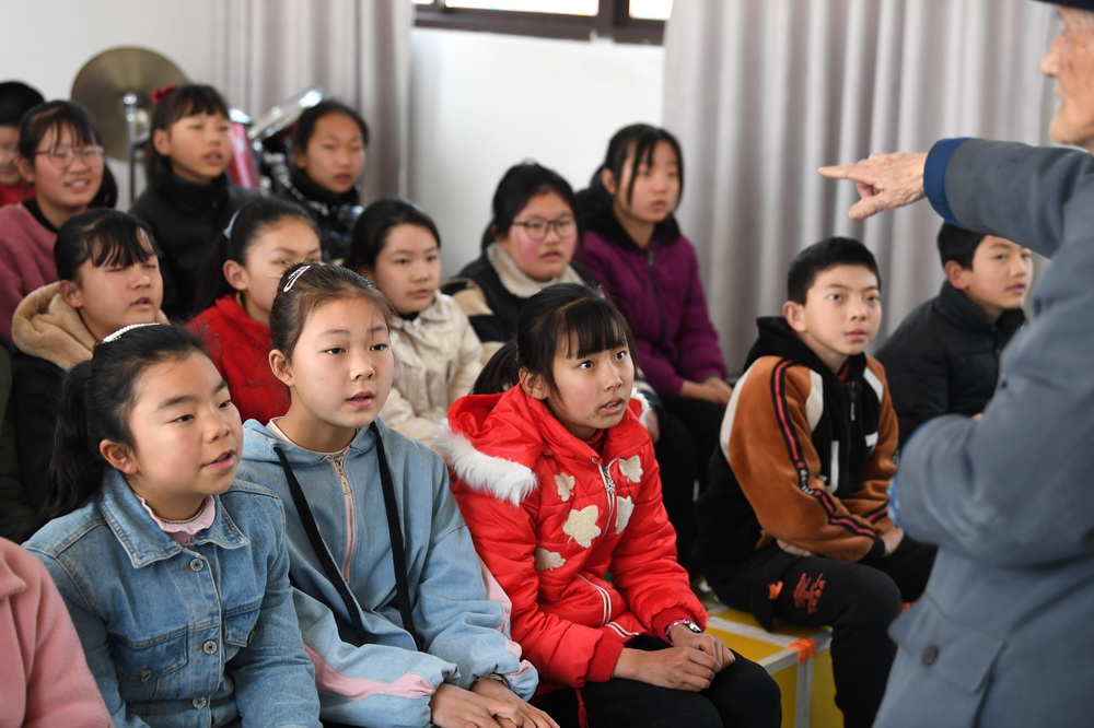 3月23日，嚴明友在朱灣小學音樂教室裡教孩子們唱歌。