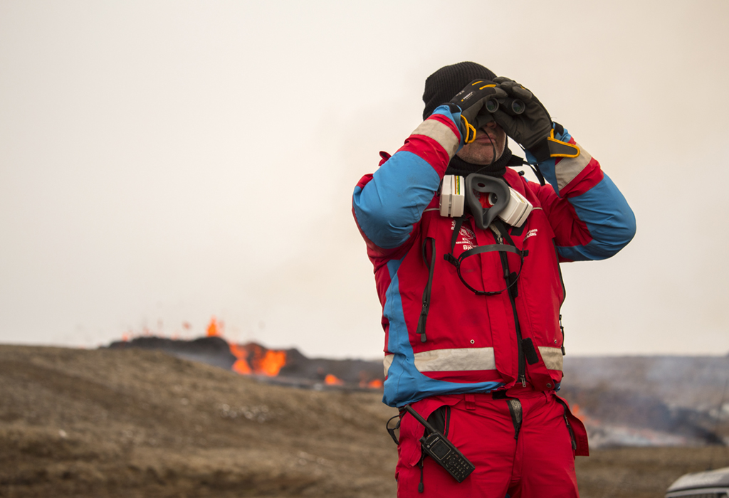 4月5日，在冰島雷克雅尼斯半島一處火山，搜救隊員站在正在噴出岩漿的裂縫旁觀察。
