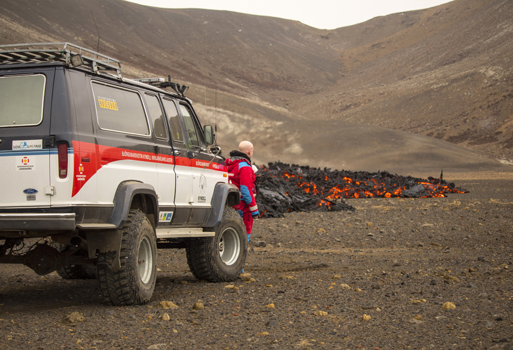4月5日，搜救隊員站在冰島雷克雅尼斯半島一處火山噴出的岩漿旁。