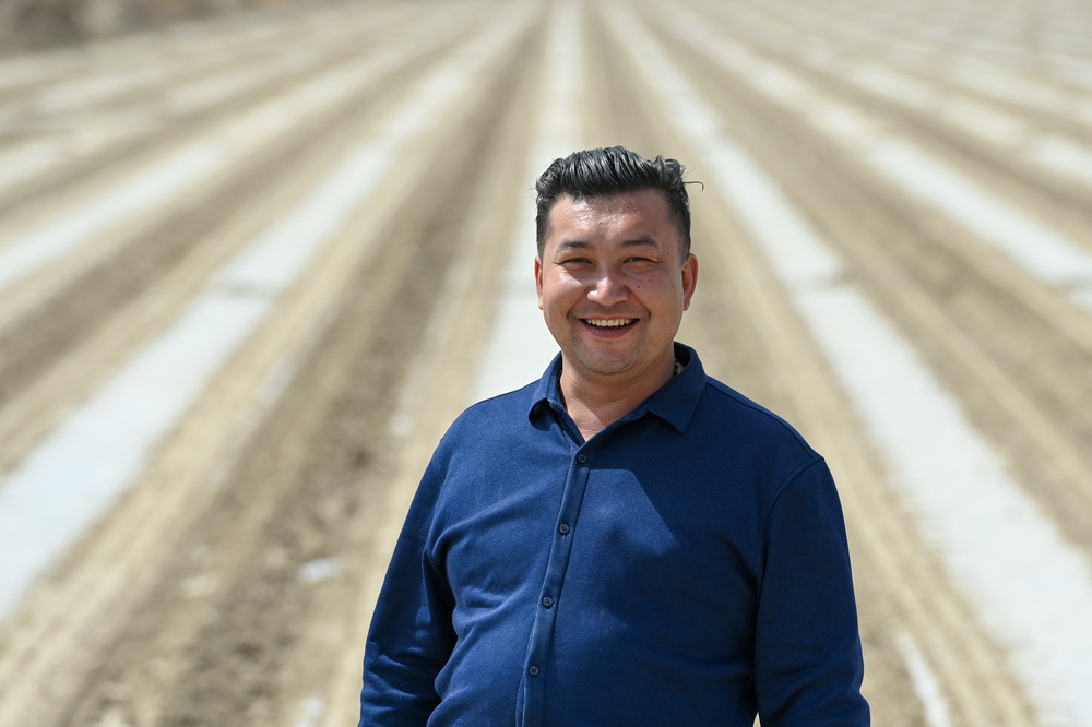 在新疆尉犁縣興平鎮通其克村，地力夏提·買買提在自家剛播種完的棉花地裡（4月13日攝）。新華社記者 丁磊 攝