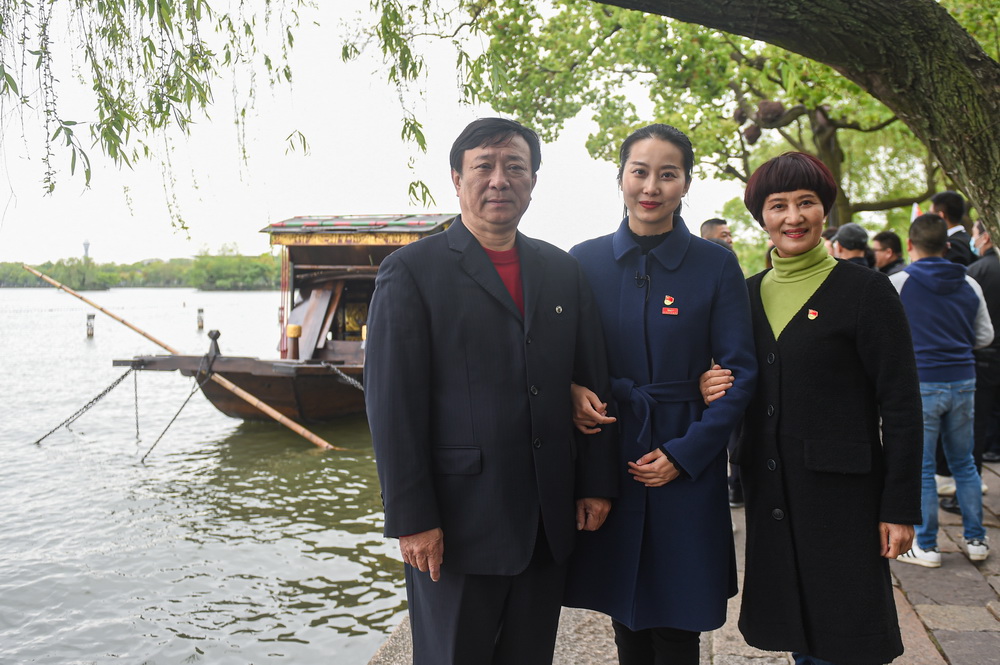 4月14日，張新志（左）、張一（中）和徐金巧一家人在紅船前合影。新華社記者 江漢 攝